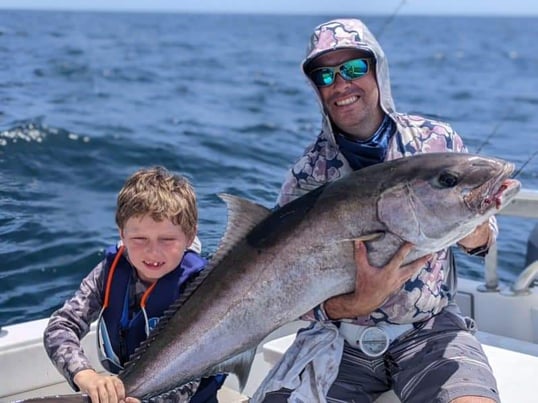 man and kid with an amberjack